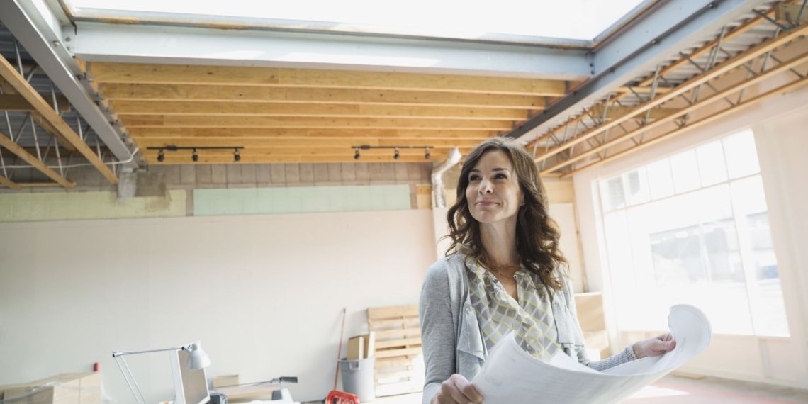 Businesswoman holding blueprints in new office 497325699 5b9ac78146e0fb0025297b7f.jpg