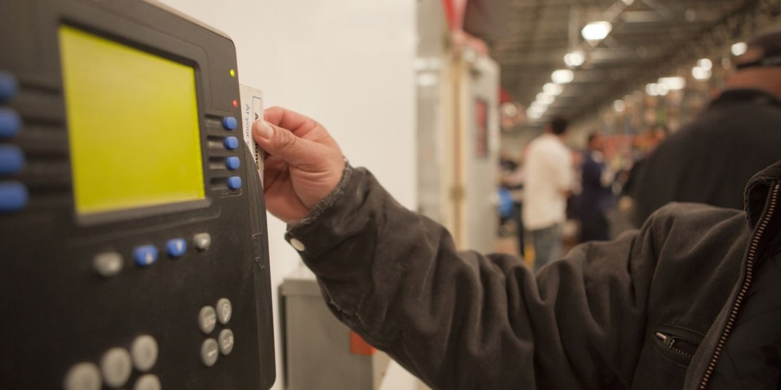 Worker scanning time clock with his id card 109954556 59652dea5f9b583f18171d55.jpg