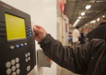 Worker scanning time clock with his id card 109954556 59652dea5f9b583f18171d55.jpg