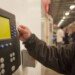 Worker scanning time clock with his id card 109954556 59652dea5f9b583f18171d55.jpg